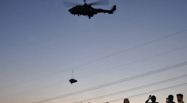 Tellere takılan paraşütçü helikopterin rüzgarıyla yere düştü